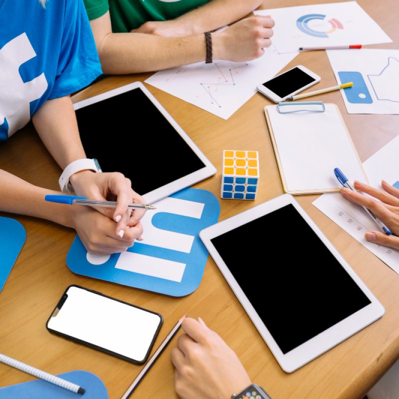 close-up-businesspeople-with-digital-tablet-social-media-icons-table